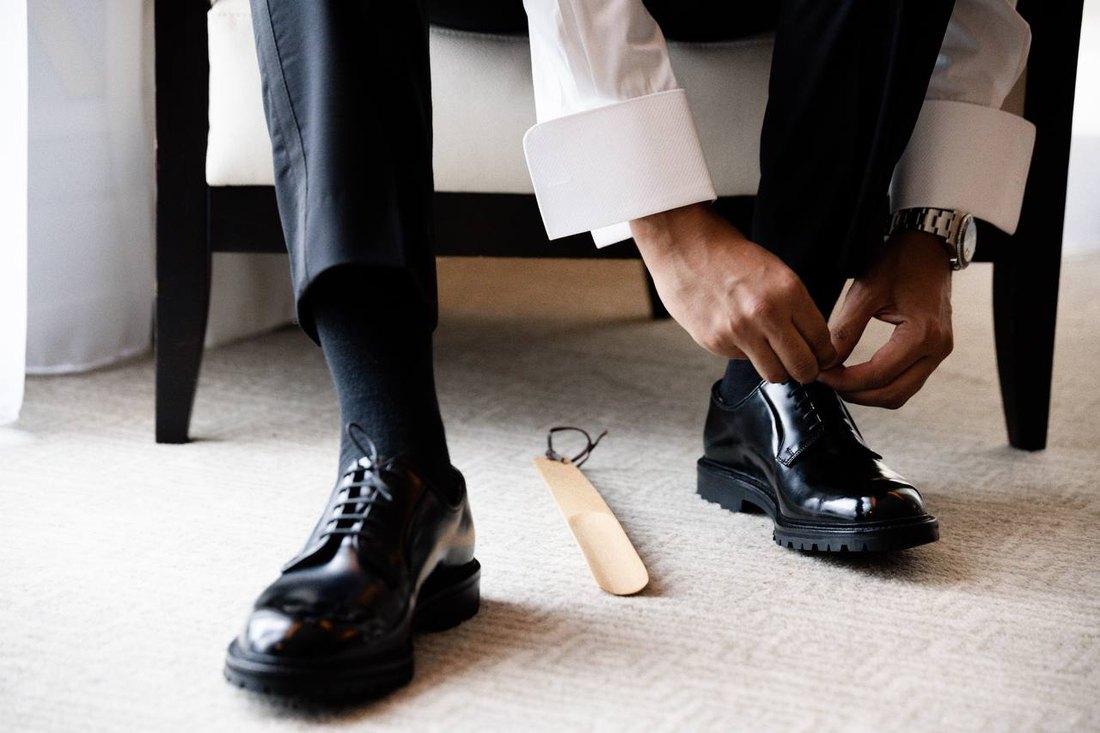 Le marié lace ses chaussures avant la cérémonie